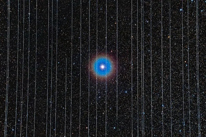 The double star Albireo behind vertical Starlink satellite trails